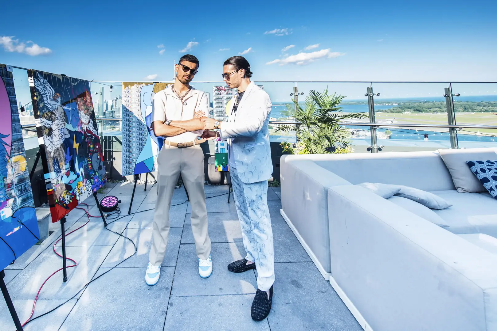 a man wearing a hat and a brown sweater using a laptop