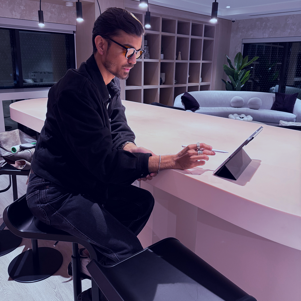 a man sitting at a table with his hand on his mouth